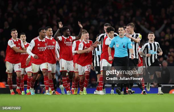 Arsenal players surround the Referee Andy Madley after a late penalty appeal during the Premier League match between Arsenal FC and Newcastle United...