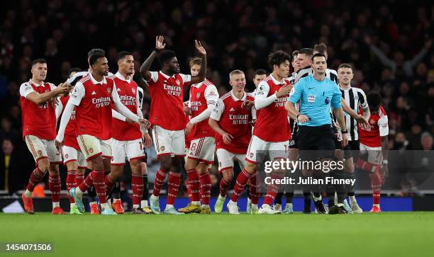 Arsenal players surround the Referee Andy Madley after a late penalty appeal during the Premier League match between Arsenal FC and Newcastle United...