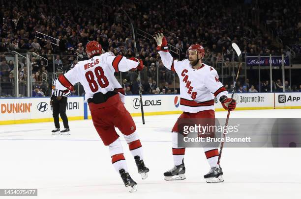 Martin Necas of the Carolina Hurricanes celebrates his first period goal against the New York Rangers and is joined by Calvin de Haan at Madison...