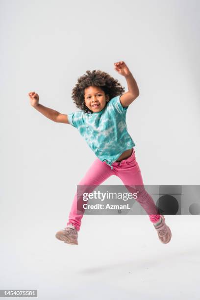 tiny caribbean girl jumping with joy - jeans barefoot girl stock pictures, royalty-free photos & images