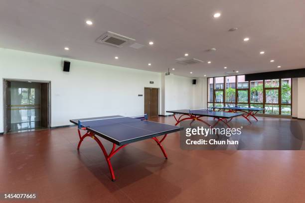 der leere indoor-tischtennisplatz ist mit tischtennisplatten ausgestattet - court room stock-fotos und bilder