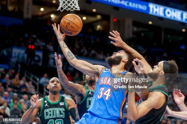Kenrich Williams of the Oklahoma City Thunder grabs a rebound over Marcus Smart of the Boston Celtics and Derrick White of the Boston Celtics during...