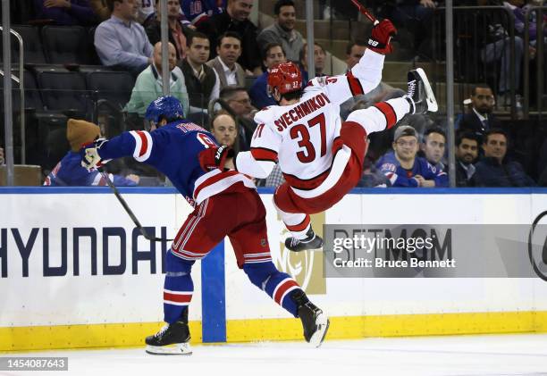 Jacob Trouba of the New York Rangers checks Andrei Svechnikov of the Carolina Hurricanes during the third period at Madison Square Garden on January...