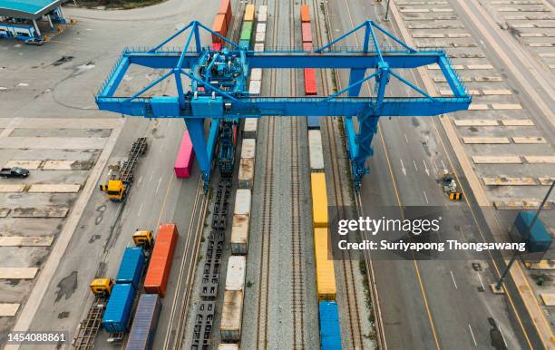 aerial view working crane bridge unload container from train to container truck at terminal commercial port for business logistics import export shipping or freight transportation. - elevator bridge - fotografias e filmes do acervo