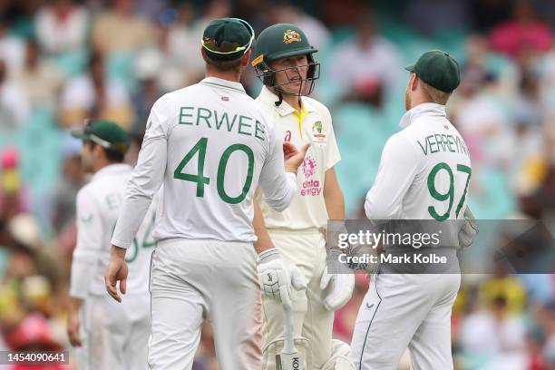 Marnus Labuschagne of Australia speaks with Kyle Verreynne and Sarel Erwee of South Africa during day one of the Third Test match in the series...