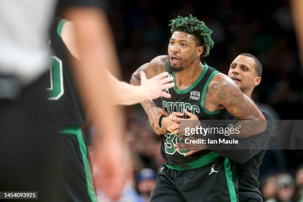 Marcus Smart of the Boston Celtics is restrained by head coach Joe Mazzulla of the Boston Celtics after being ejected during the third quarter...