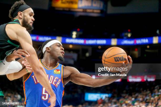Luguentz Dort of the Oklahoma City Thunder grabs a rebound over Derrick White of the Boston Celtics during the third quarter at Paycom Center on...
