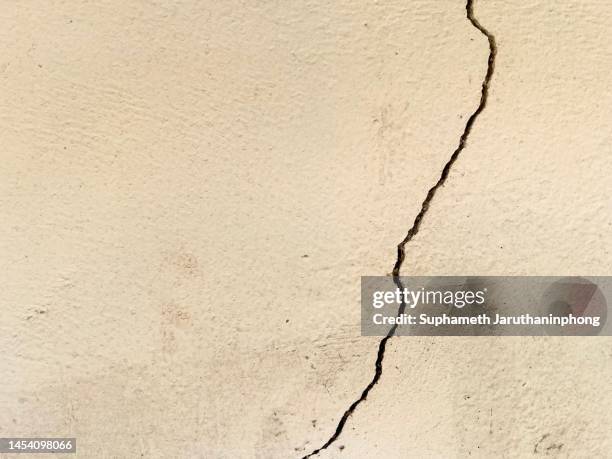 a cracking yellow wall. single line of fracture. - earthquake house stock pictures, royalty-free photos & images