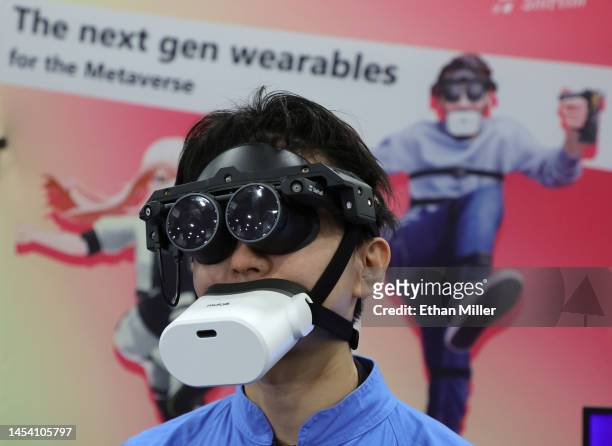 Tomohiko Fukaya demonstrates Shiftall’s full-body tracking device, including the mutalk Bluetooth microphone over his mouth and the MeganeX VRE...