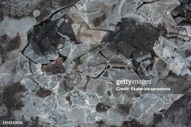 broken ice in a puddle. a frozen puddle of water. - broken glass pieces stock pictures, royalty-free photos & images