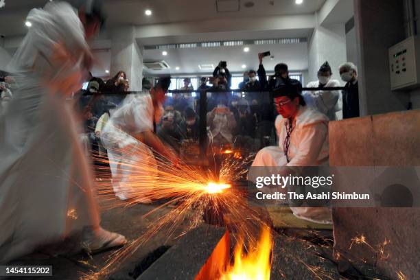 Japanese swordsmiths wearing a traditional costume forge metal to create a Japanese sword at the ceremony marking the new year on January 2, 2023 in...