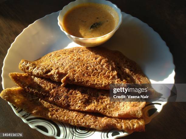 ragi/finger millet and whole wheat dosa with coconut chutney in a ceramic plate on a wooden table - ahmedabad stock pictures, royalty-free photos & images