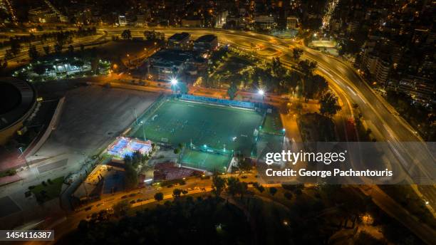 aerial photo of illuminated soccer field and urban highway at night - soccer field empty night imagens e fotografias de stock