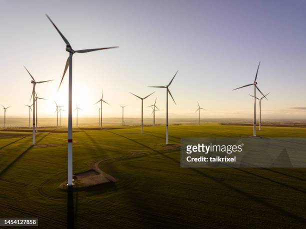 luftaufnahme von windkraftanlagen bei abendlicht - windenergie stock-fotos und bilder