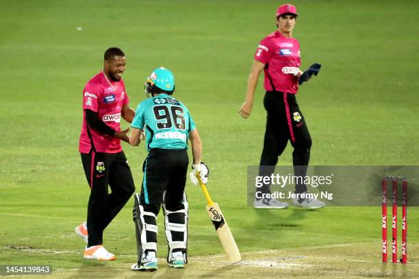 Chris Jordan of the Sixers attends to Nathan McSweeney of the Heat as he was hit by the ball during the Men's Big Bash League match between the...