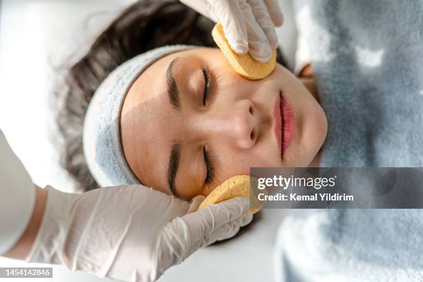 happy woman receiving a beauty treatment - facial spa treatment stock pictures, royalty-free photos & images