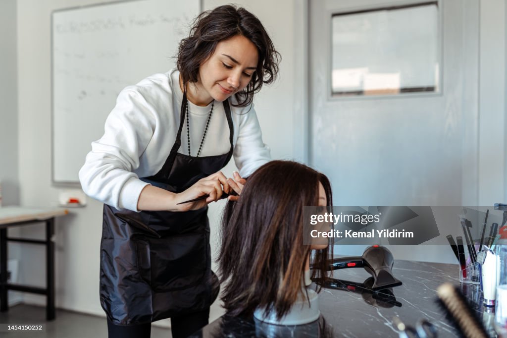 Ein Student arbeitet als Friseur mit einem Dummy