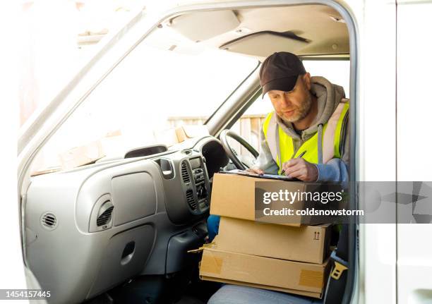 delivery driver in van with parcels on seat - parcel delivery stock pictures, royalty-free photos & images