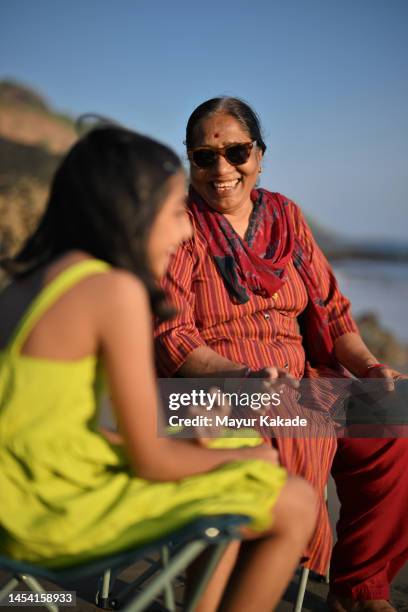 close-up of granddaughter and grandmother spending good time on the beach - indian family vacation stock pictures, royalty-free photos & images