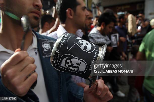 Palestinian protestors bang on pots covered in pictures of Palestinian prisoners Mahmoud al-Sarsak and Akram al-Rikhawi , who are still refusing food...