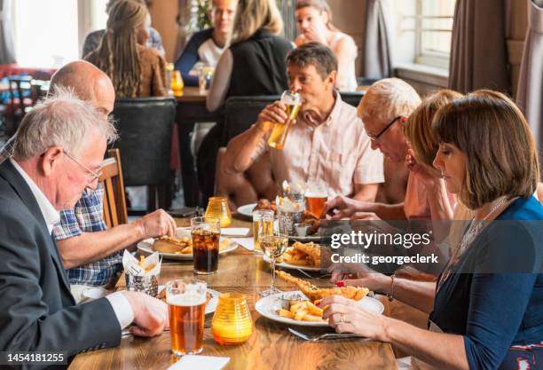 freunde essen zusammen in einem englischen gastropub - kneipengericht stock-fotos und bilder