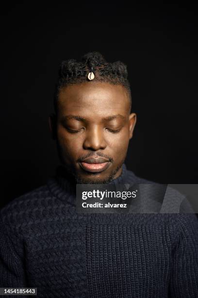 portrait of african man with eyes closed on black background - blank expression stock pictures, royalty-free photos & images