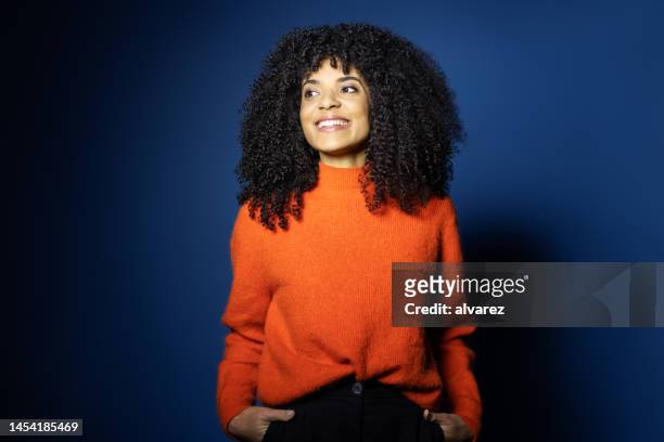 portrait of beautiful young woman in red sweater - blue background portrait bildbanksfoton och bilder