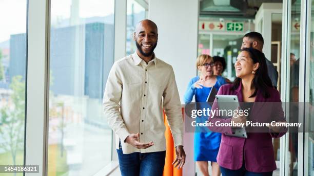 diverse businesspeople walking together to a meeting in an office - business casual talking stock pictures, royalty-free photos & images