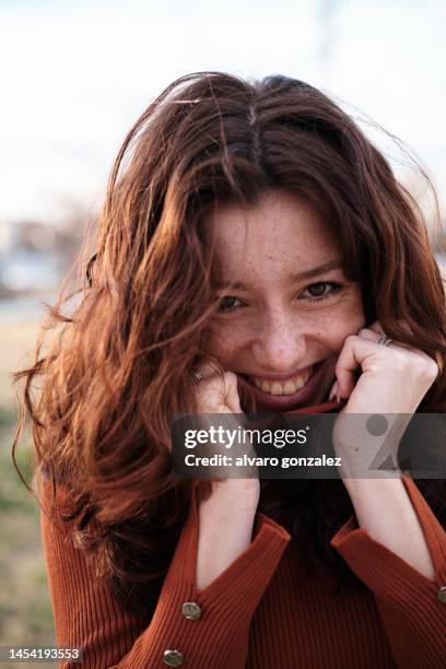 shy beauty woman smiling in the cold outside - hand on chin stock-fotos und bilder