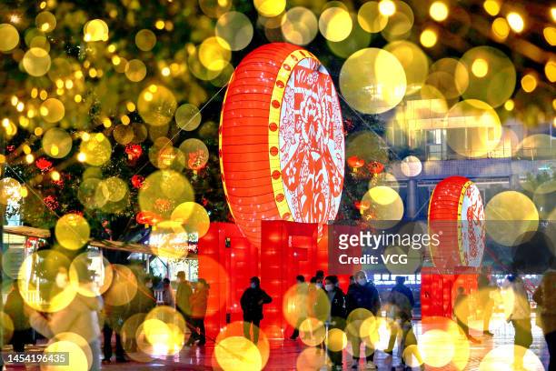 People walk by illuminated lanterns at a square ahead of Chinese New Year, the Year of the Rabbit, on January 4, 2023 in Chongqing, China.