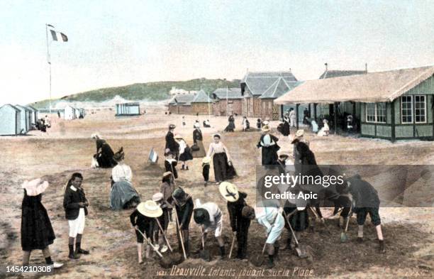 Children playing on the beach in Deauville, Normandy, France, postcard, circa 1900.
