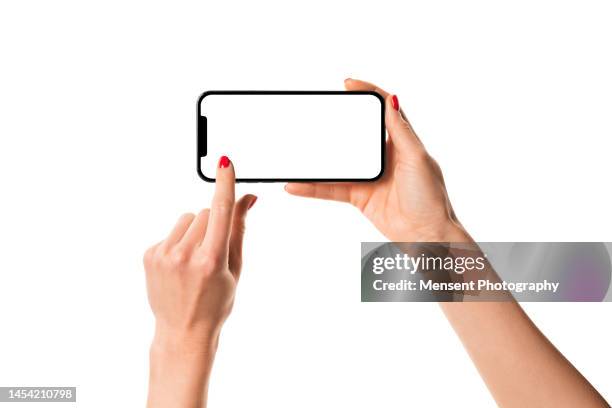 woman hand holding modern frameless smartphone mockup with white screen on white background - querformate stock-fotos und bilder