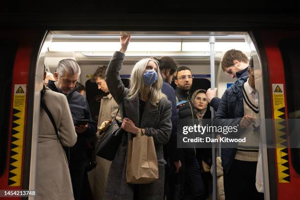 Commuters wear face masks on the underground on January 04, 2023 in London, England. 10 Downing Street has stressed that it is not compulsory to wear...