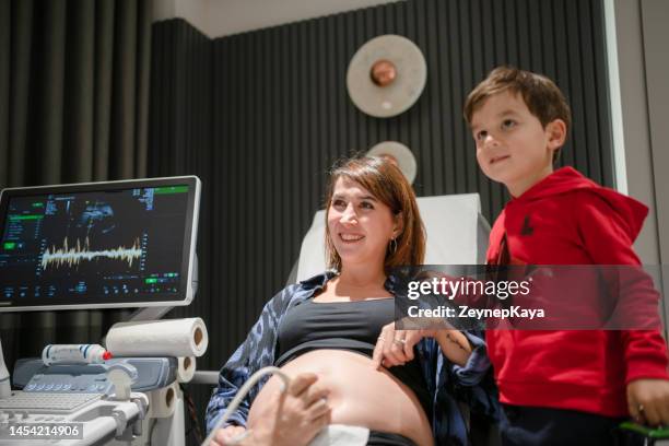 boy watching his mother's ultrasound - patients brothers 個照片及圖片檔