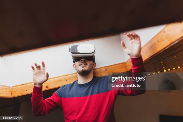 portrait of an amazed man using a virtual reality glasses at home interior. - gesture control screen stockfoto's en -beelden