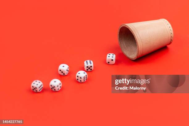 dice spilling out a dice cup on red background. - würfel stock-fotos und bilder