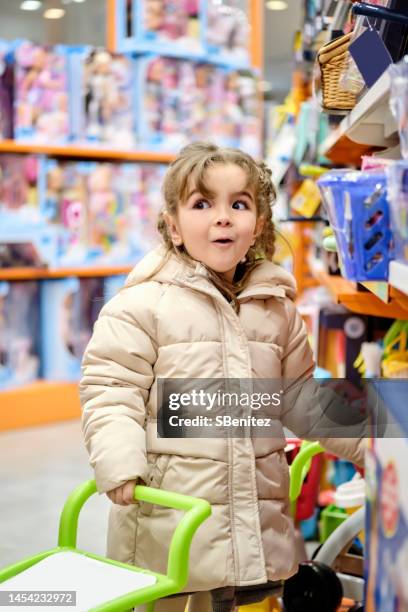 little cute girl selecting toy in kids store - mini grocery store photos et images de collection