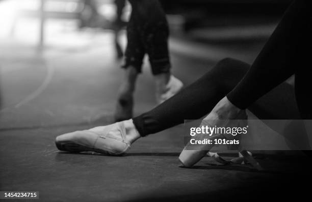 young ballerina in black tights tying ribbon on point shoe - stockings feet 個照片及圖片檔