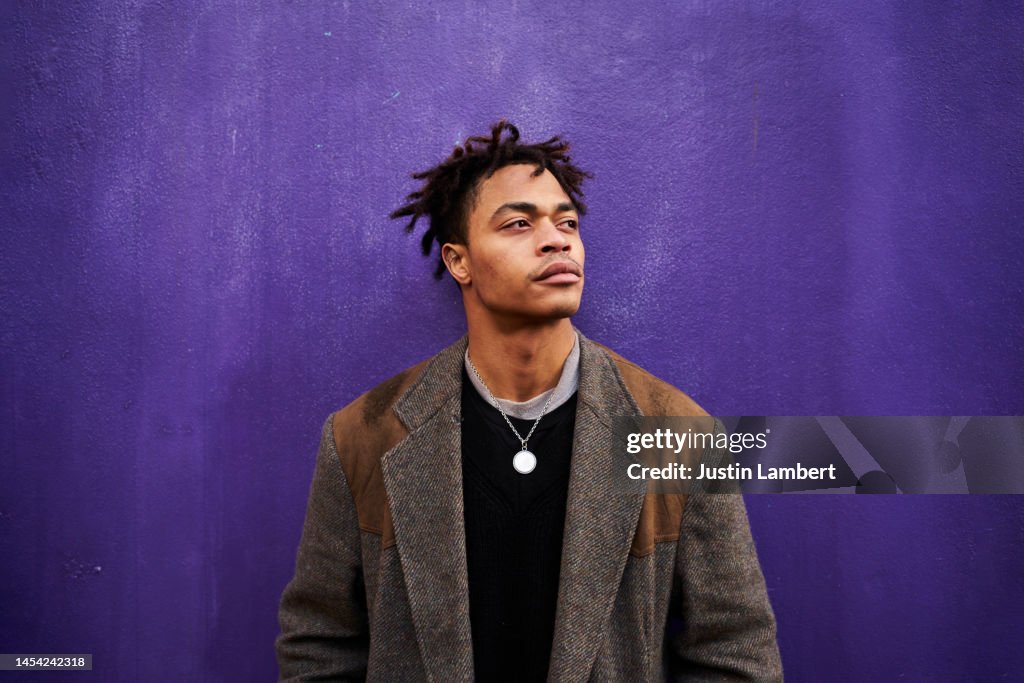 Portrait of a man looking away shot against a purple backdrop