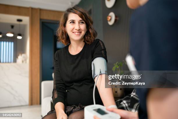 nurse measuring pregnant woman's blood pressure - medical technical equipment stock pictures, royalty-free photos & images