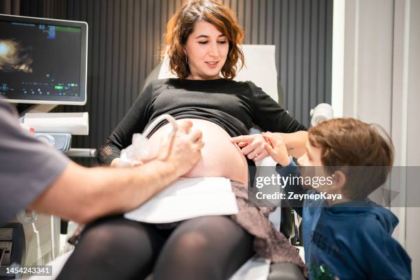pregnant mom having a checkup at the doctor's office with her son - fase da reprodução humana imagens e fotografias de stock