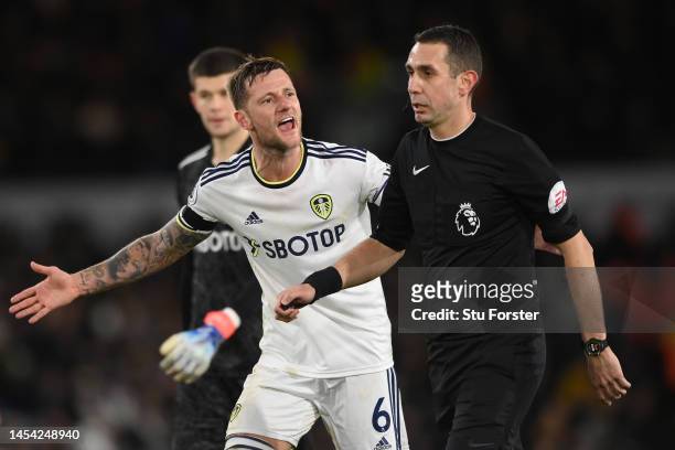 Liam Cooper of Leeds United argues with referee David Coote after VAR awarded West Ham United with a penalty during the Premier League match between...