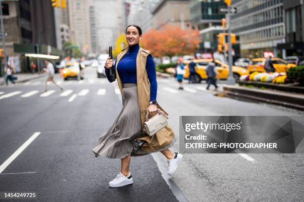 une femme vue traversant la rue à new york pendant une journée de travail bien remplie - skirt stock photos et images de collection