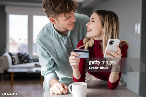 young couple using e-commerce online services - two men shopping stock pictures, royalty-free photos & images