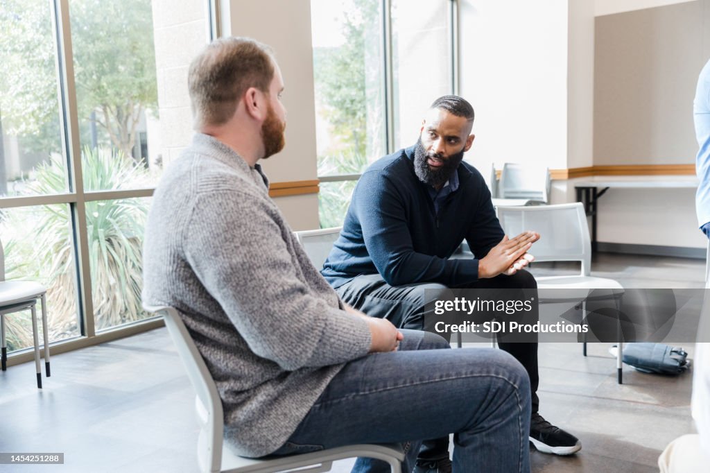 Two diverse men have intense conversation before meeting