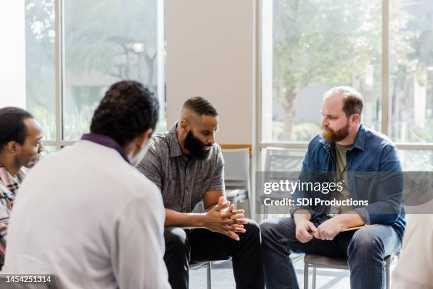 therapy group waits for mid adult man to share - mental illness stock pictures, royalty-free photos & images