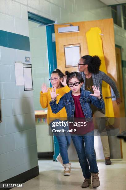 l’enseignant et les enfants font un exercice de sécurité à l’école, évacuent - accidents in schools photos et images de collection