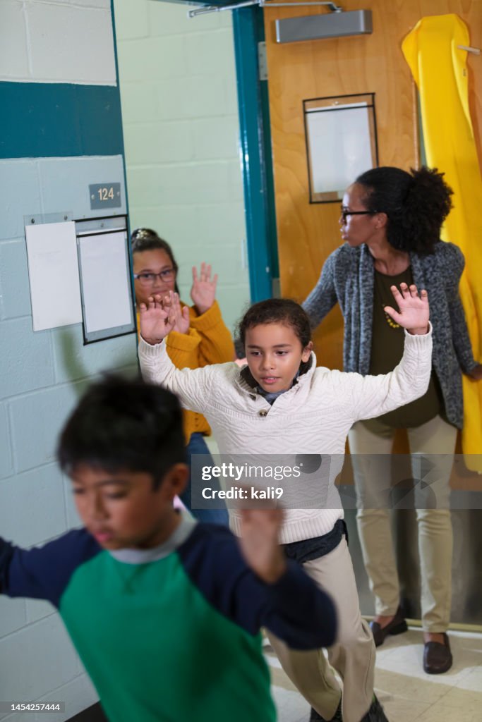 Teacher and children doing school safety drill, evacuating