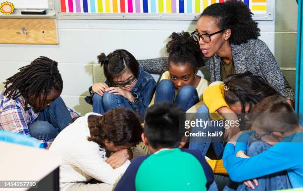 teacher and children doing school safety drill, lockdown - lockdown drill stock pictures, royalty-free photos & images