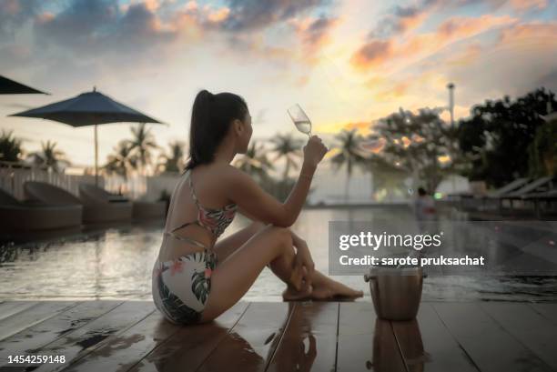 luxury holiday .elegant women celebrate on swimming pool with cold alcoholic cocktail. - drinkwater kante stock-fotos und bilder